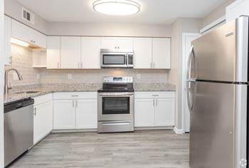 A kitchen with white cabinets and stainless steel appliances
